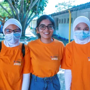 Kavya Krishna with two others, all wearing orange shirts
