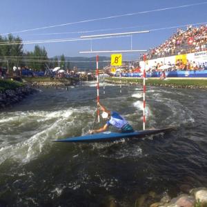 a kayaker in a water course. Spectators watching from the stands