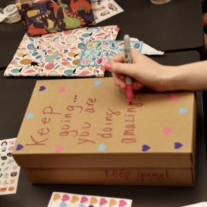 hand writing on a shoe box "keep going you are doing great"