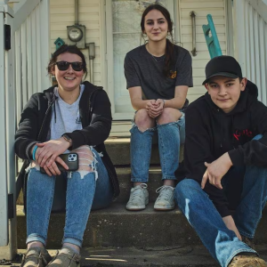 Three kids sit on steps