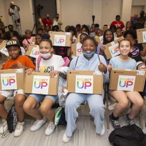 lage group of kids seated, pose with laptops from project UP