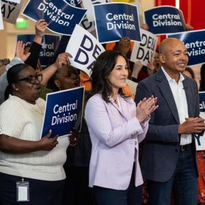Kim Kleinhans and  Jason Gumbs in front of people holding DE&I Day signs