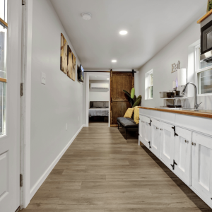 Kitchen with white cabinets & custom wood counter tops in up-cycled shipping container 