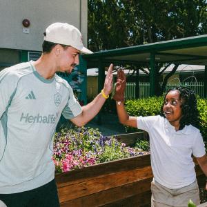 A student high-fives LA Galaxy’s JT Marcinkowski.