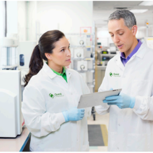 Two people in lab coats talking.