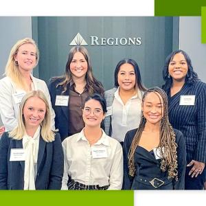 Six people posed, a Regions sign behind them.