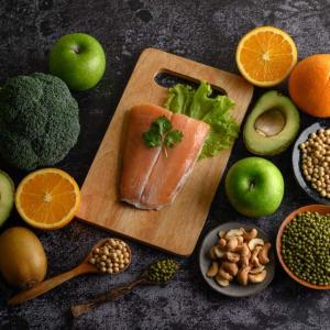Legumes, vegetables and fruits shown on a cutting board.
