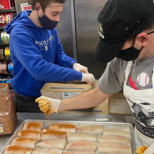 Volunteers prepping fish to cook