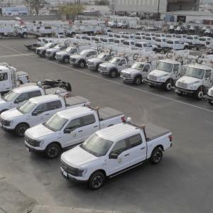 Aerial view of a parking lot full of identical trucks and service vehicles.