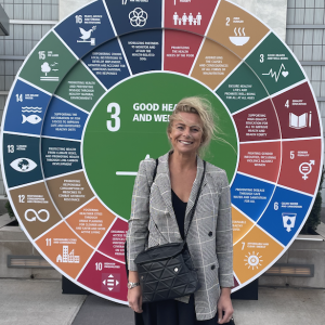 Lina Andersson stood outside in front of a good health and wellbeing board