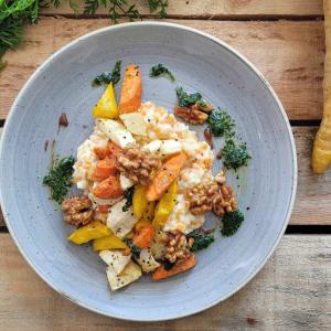 Plate of lentil risotto surrounded by bunches of carrots