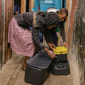 Two people assembling a loope toilet.