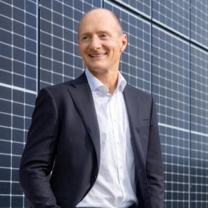 Magnus Groth standing in front of solar panels