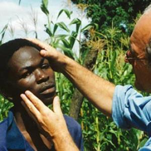 A person examines the eye of another