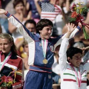 Three medalists waving to an audience 