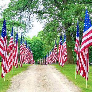 American flags line both sides of a dirt path.