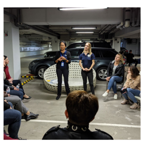 Two people standing with others in a circle around them.