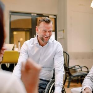 Person laughing with two others