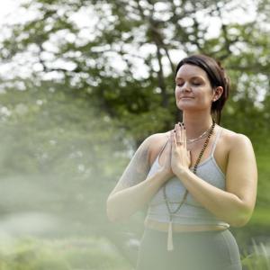 Kimberly Hoffmann doing a yoga pose outside.
