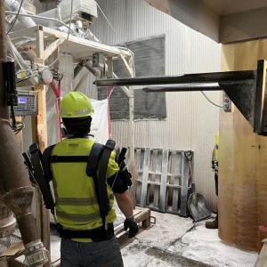 A person in protective gear in a manufacturing area.
