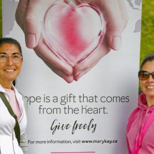 two people standing in front of a banner about the event