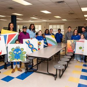 group showing off their paintings 