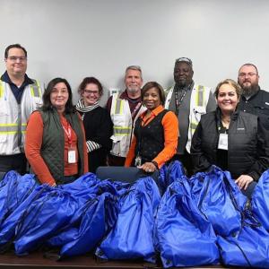 group of volunteers behind a pile of stuffed blue sacks