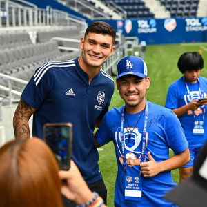 Student posing with an MLS player