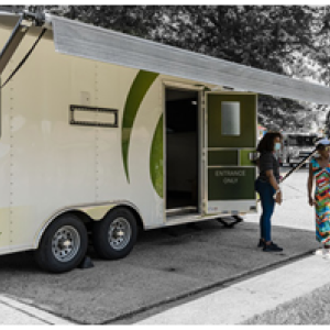 A large trailer with awning, side door open and two people talking outside. "Quest diagnostics on the side.