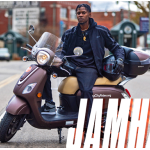 A person on a scooter on a city street.