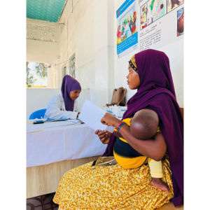At an Action Against Hunger-supported clinic in Kismayo, a mother is informed about the importance of vaccines for malnutrition prevention. 