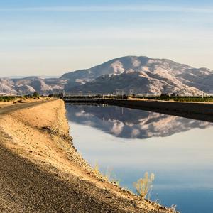 A dirt road with mountains in the background