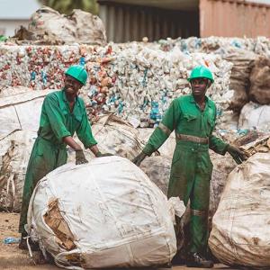 three people cleaning up plastic recycling 