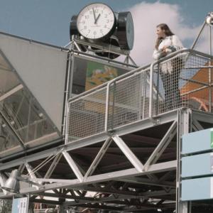 a person in spectator stands, picture based signage below them