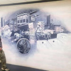 Malcolm Smith standing next to a mural on a wall.