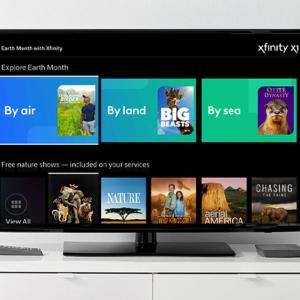 A tv on a stand. Screen showing a selection of shows.