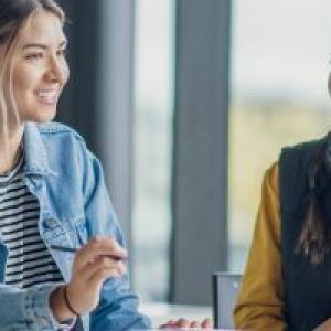 Smiling people talking at a table.