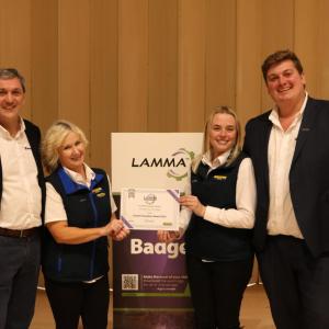Four people standing together holding an award