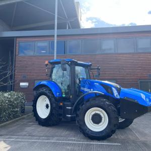 A blue New Holland tractor in a parking lot.