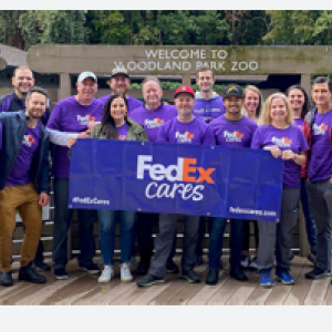 A group of volunteers posed outside with a FedEx Cares sign.