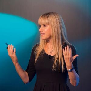 Nicoletta Luppi speaking, with hands raised, looking to her right