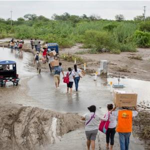 Doctors walk or are transported on a truck after attending to a medical volunteer campaign supported by local health organization Vida Peru, with medical aid from Direct Relief, during flooding from the 2017 El Niño events in the country. (Photo by Enrique Castro-Mendivil for Direct Relief)