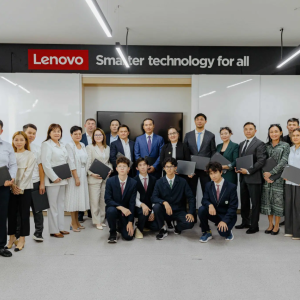A group under a sign that reads: "Lenovo - Smarter technology for all"