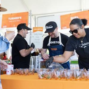 Volunteers pouring drinks on a table with an orange covering