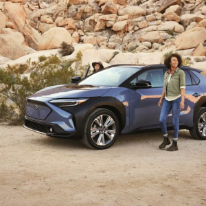 Person standing next to a Subaru vehicle