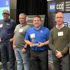 A row of posed people, one holds the award