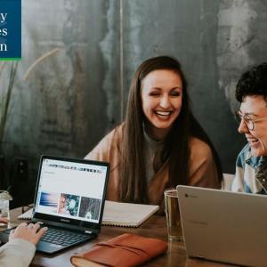 Three people sat at a table on laptops