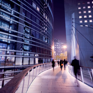 People on a walkway between two tall buildings