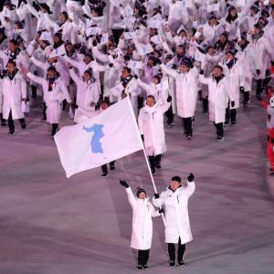 Large coordinated team carrying their flag at an opening ceremony