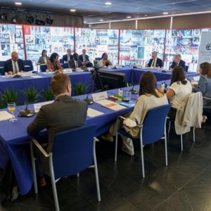 conference of many people seated at a u-shaped table